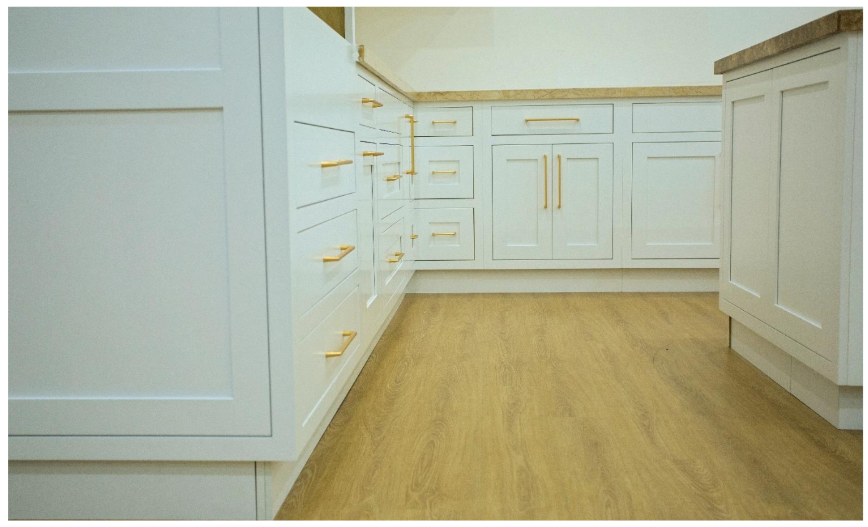 Wide angle view of white inset cabinet kitchen showing flush door profile and consistent reveal lines with gold bar pulls